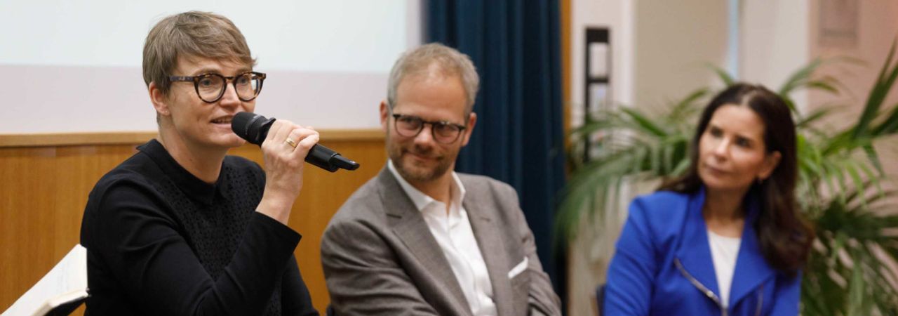 Eva Czernohorszky spricht bei einer Konferenz, daneben Klemens Himpele und Sonja Kato