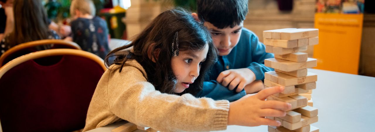 Zwei Kinder spiele ein Geschicklichkeitsspiel.